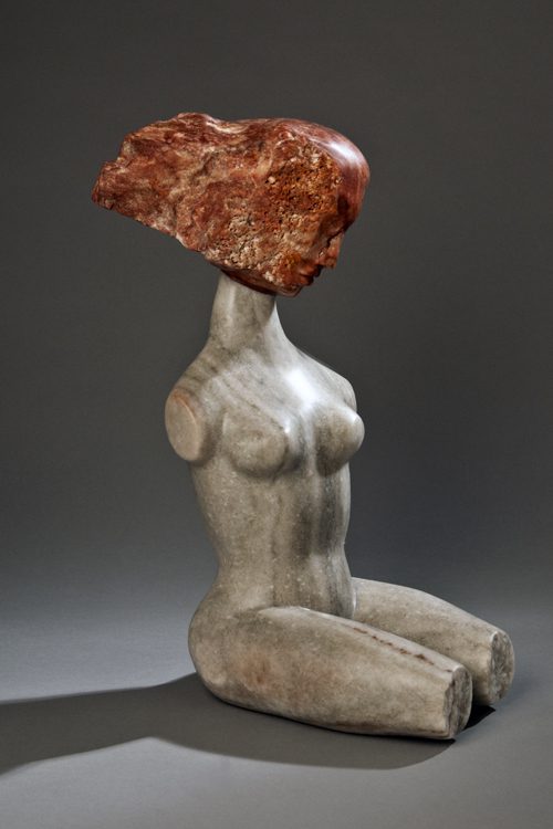 A statue of a woman with a piece of meat on her head.